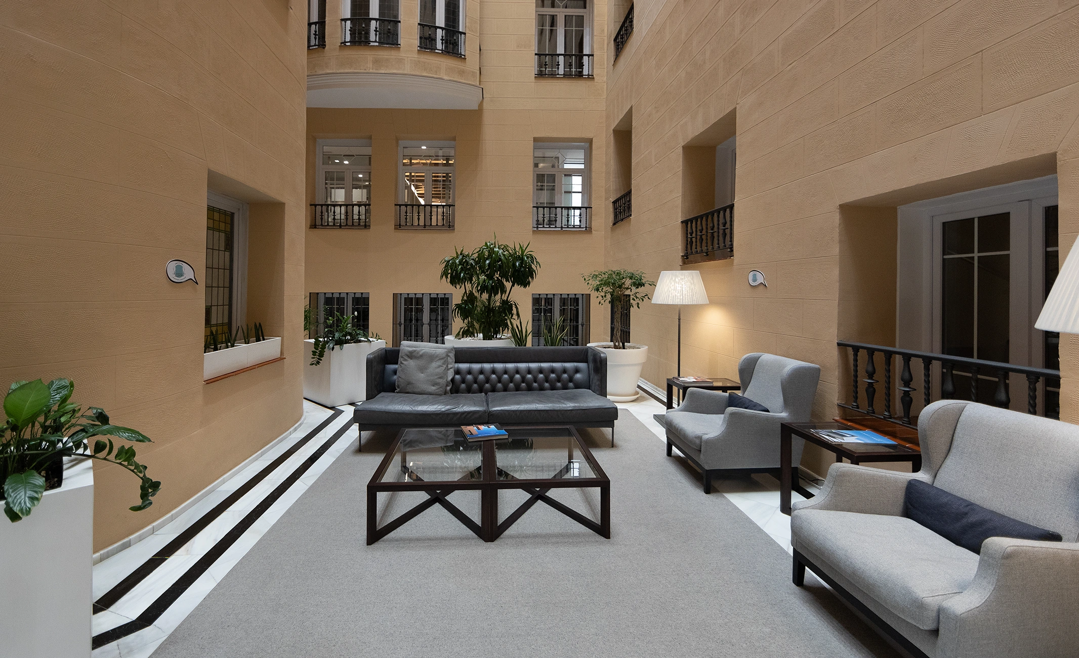 Fotografía de recepción y lobby de despacho profesional con mobiliario elegante