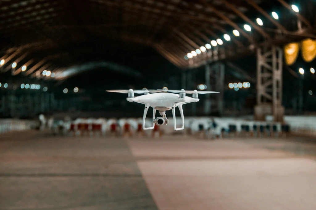 Dron volando en pabellón de eventos corporativos listo para grabar cobertura aérea profesional