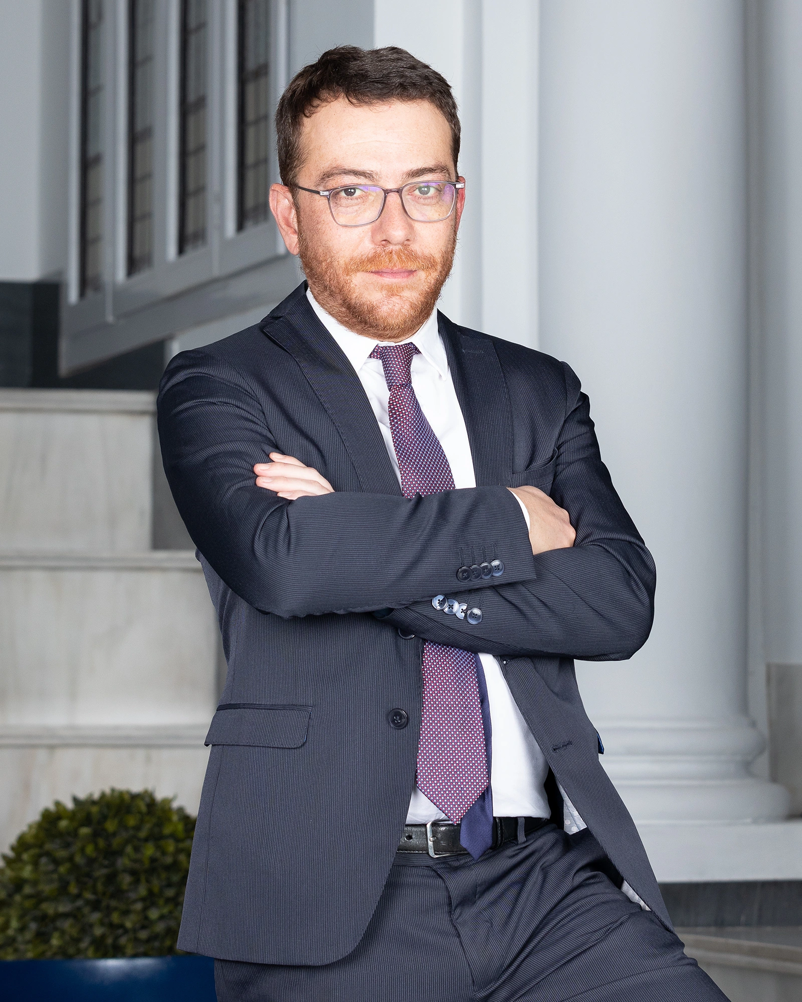 Retrato corporativo de directivo con brazos cruzados en oficina