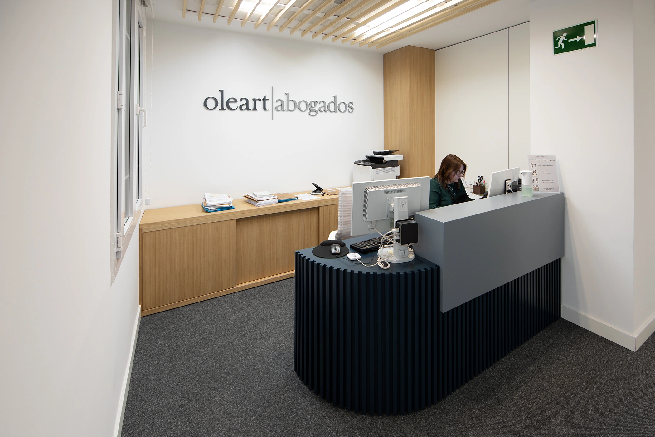 Fotografía de cultura de empresa — recepcionista trabajando en despacho de abogados con logo corporativo