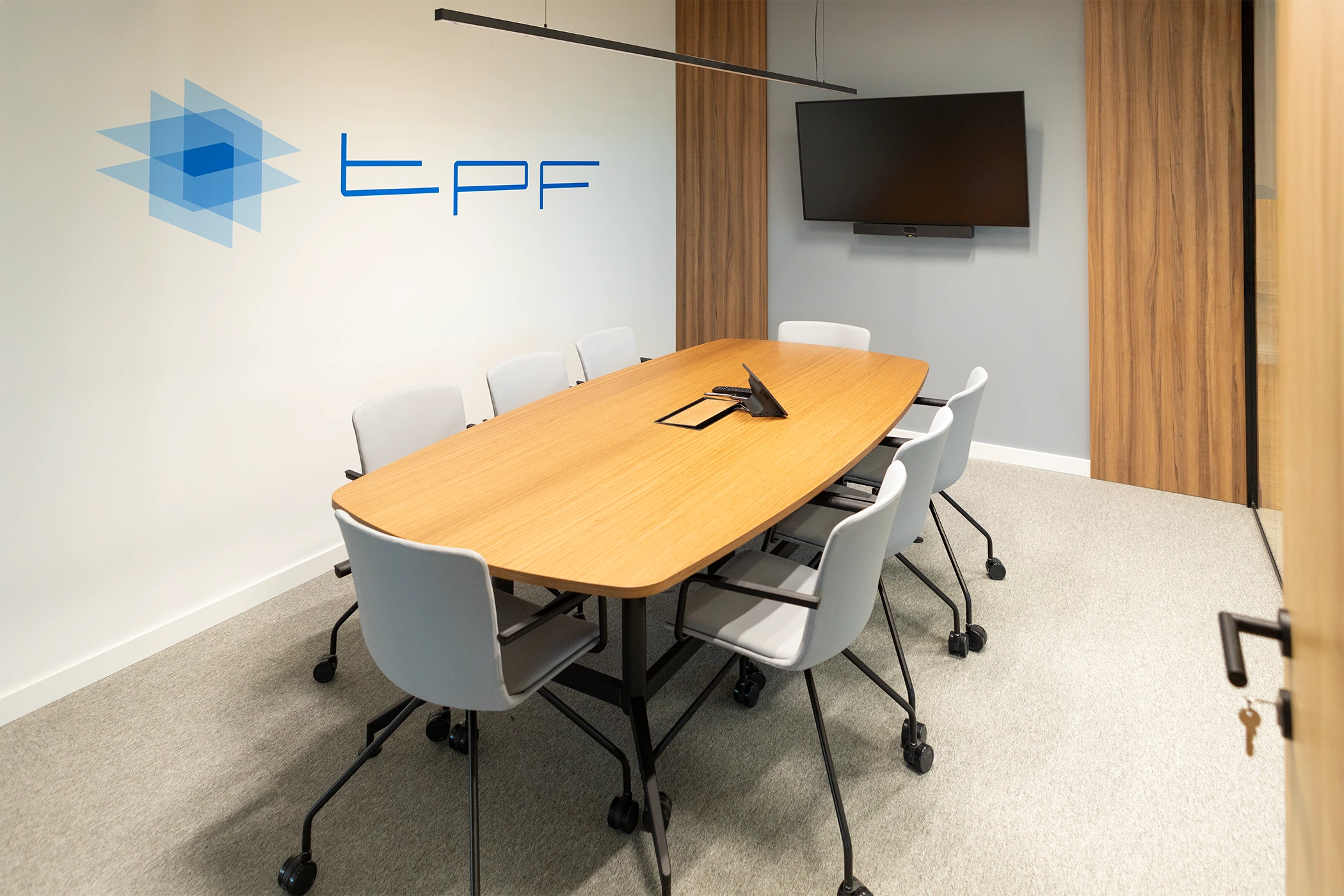 Fotografía de sala de reuniones corporativa con logo de empresa y pantalla de presentación