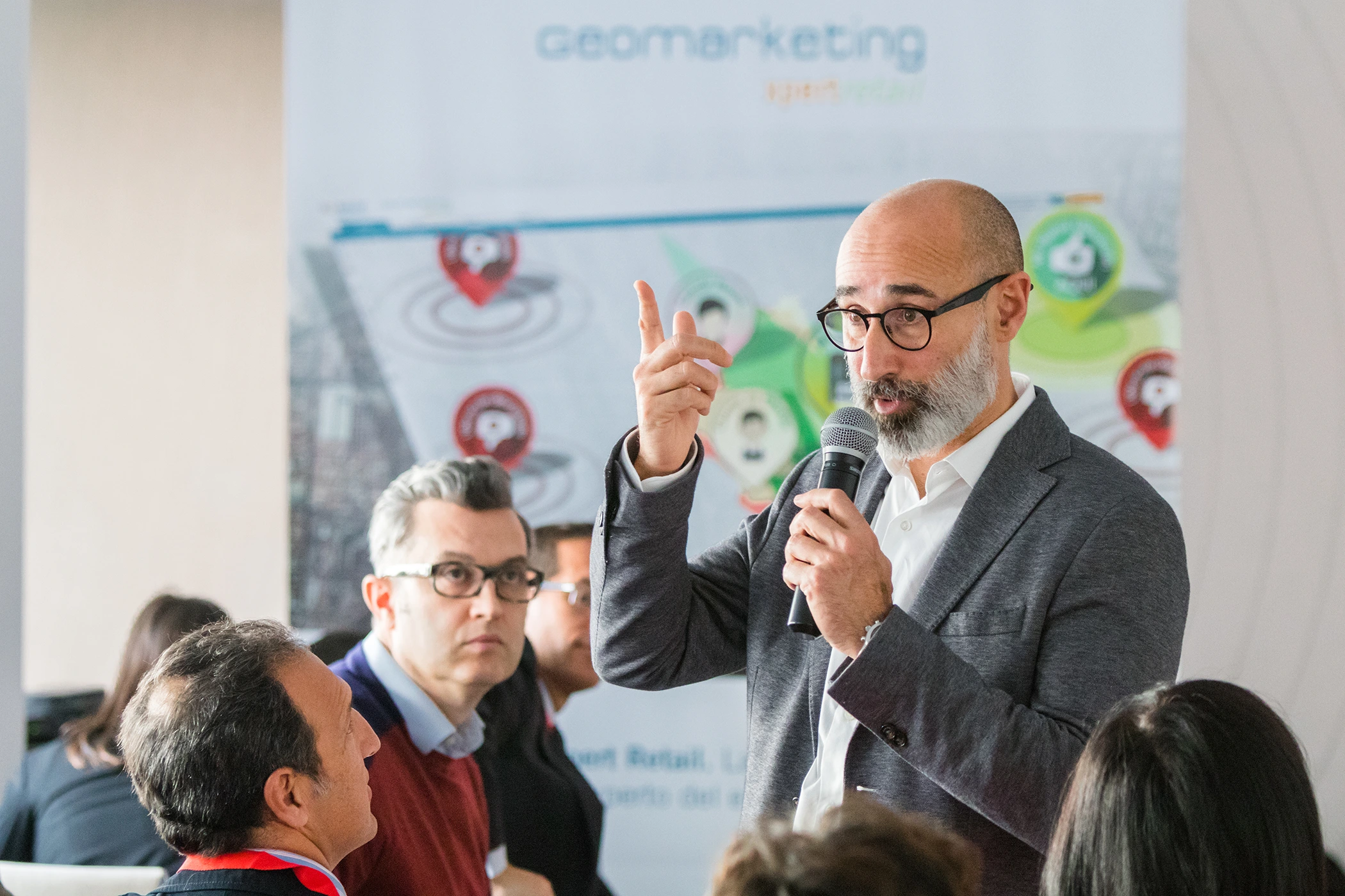 Ponente directivo respondiendo a preguntas durante sesión de debate en jornada profesional con audiencia de empresa